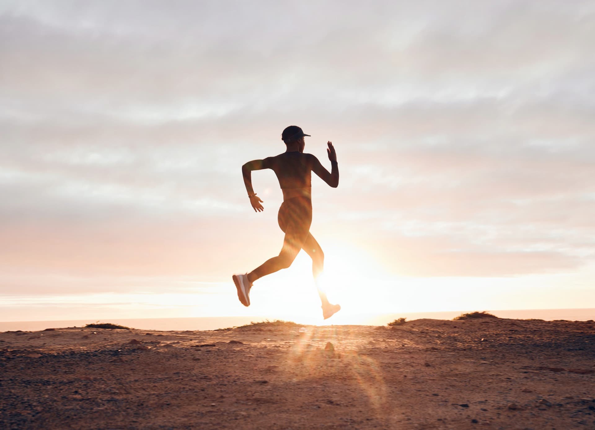 Silhouette of a trail runner at sunrise